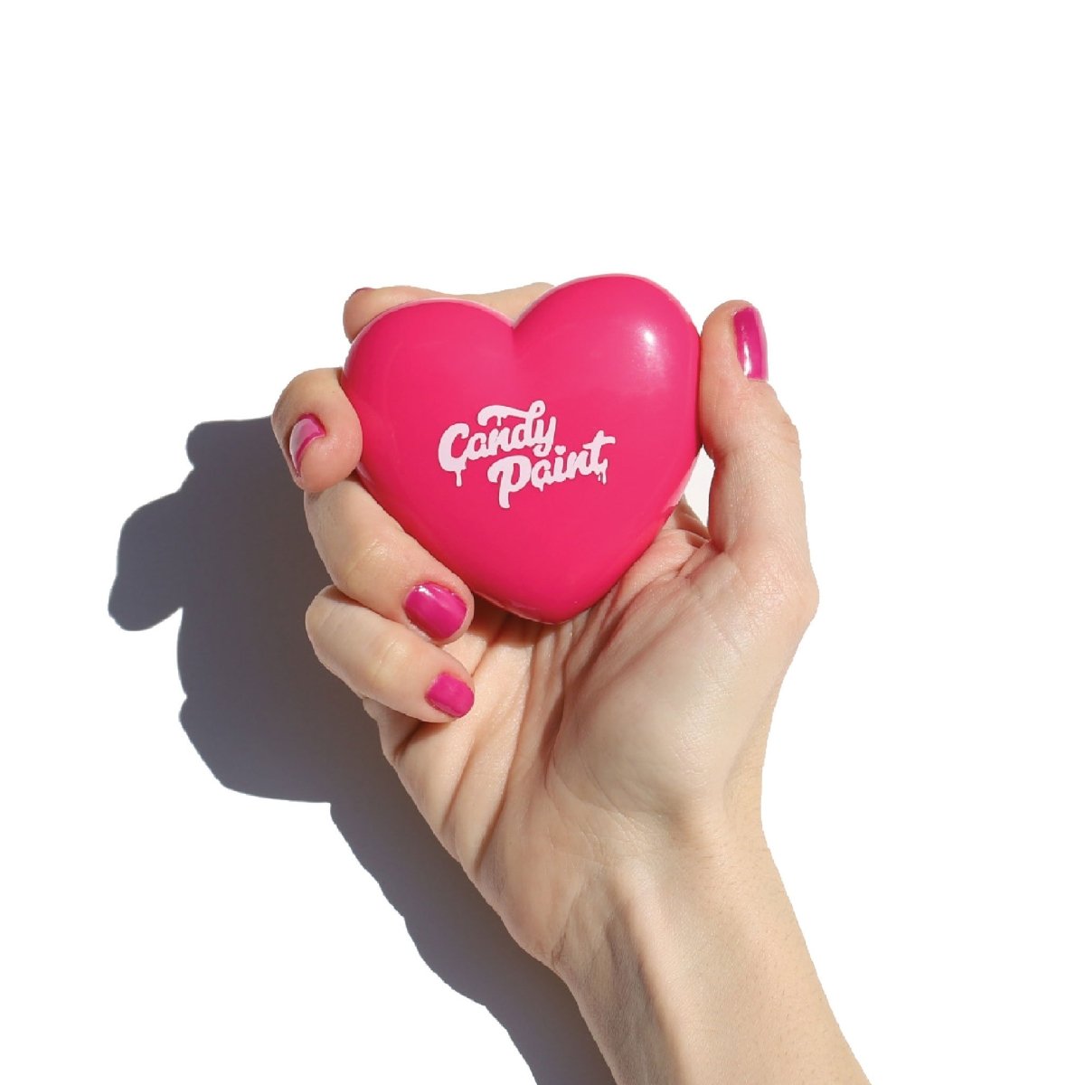 pink heart shaped compact in hand with pink fingernails - candy paint cheek + lip tint - half caked makeup