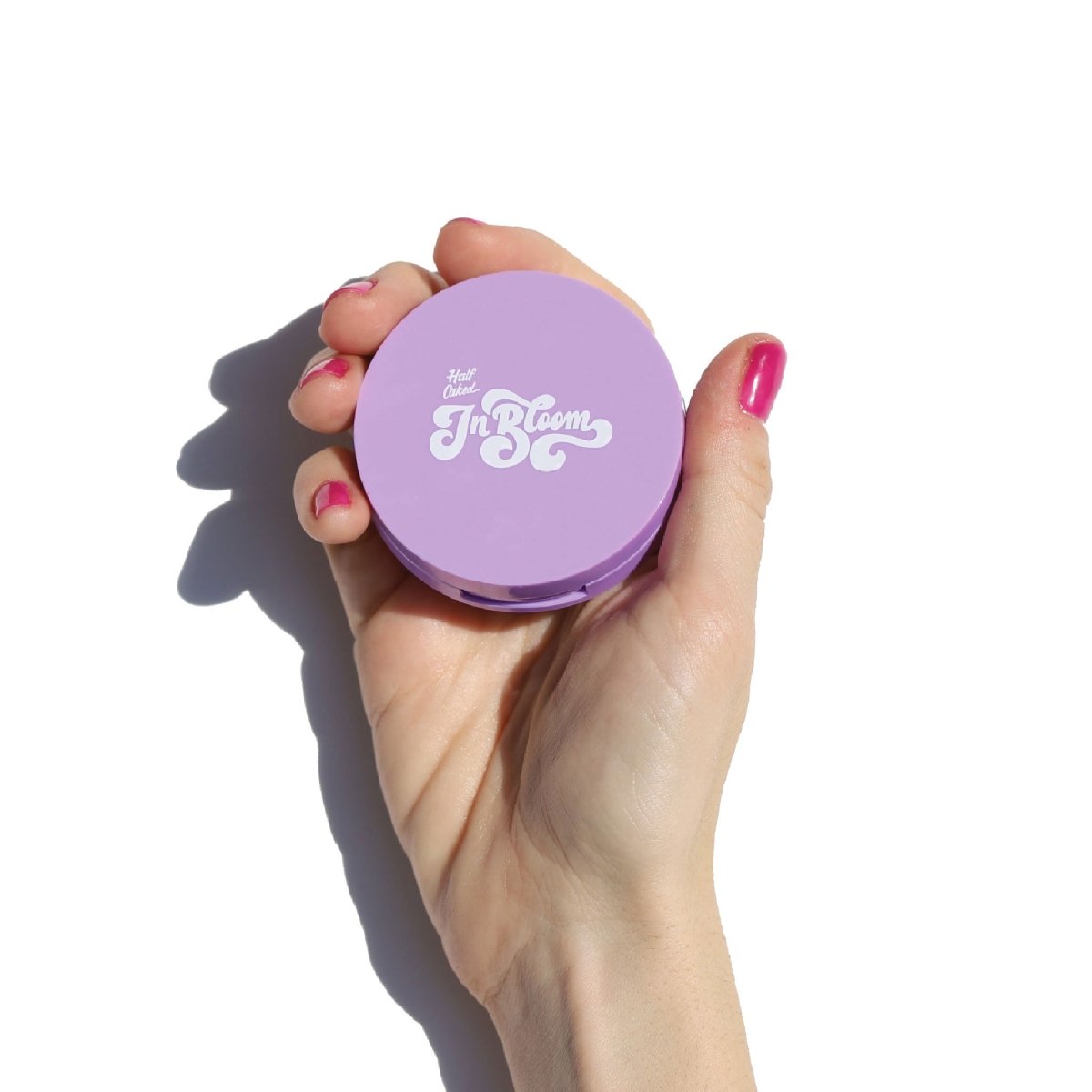 purple compact in hand with pink nails - In Bloom Powder Blush - Half Caked