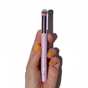 shiny purple concealer brush in hand with yellow nails - Mini Buffer Brush - Half Caked