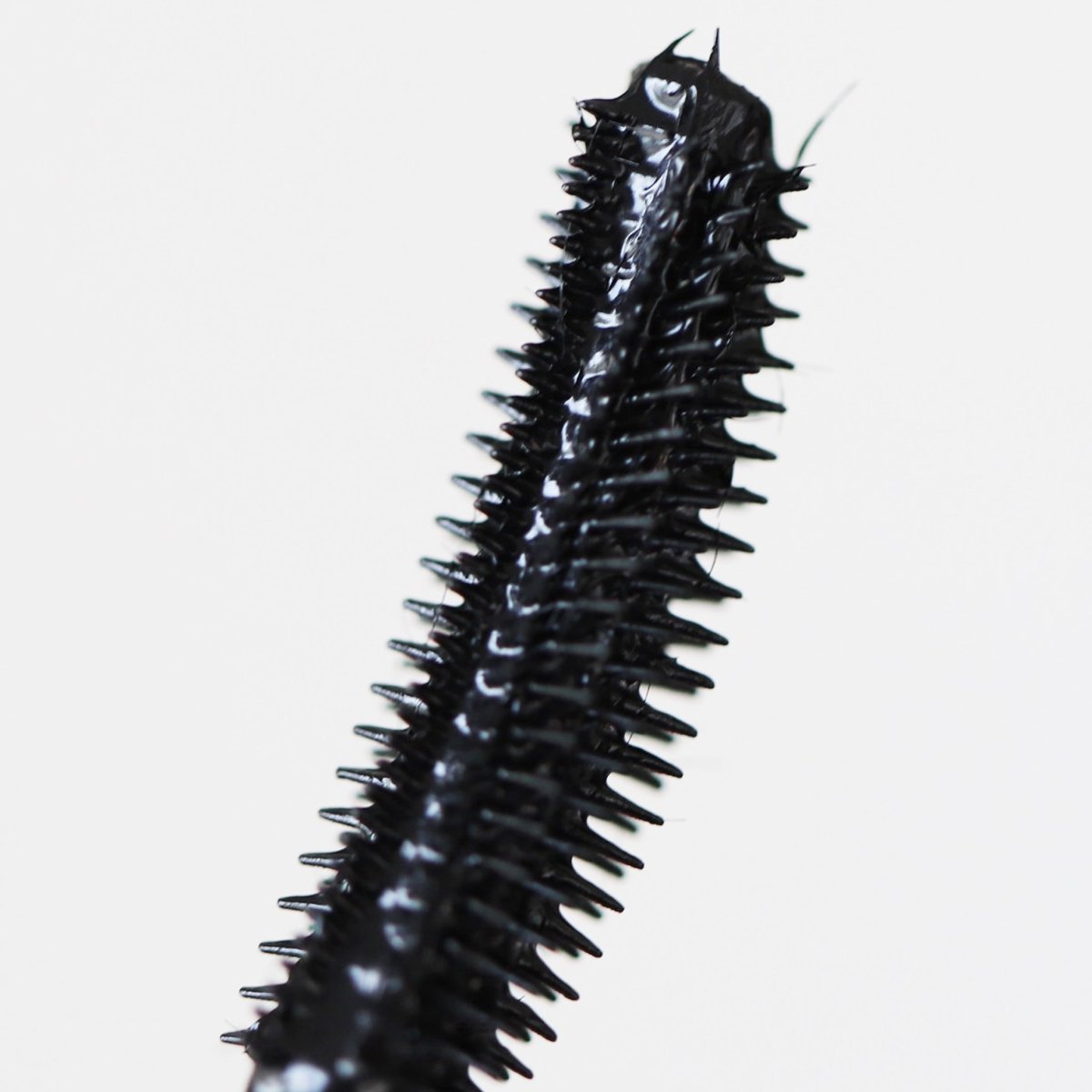closeup of black plastic curved mascara applicator - Totally Tubular Bundle - Half Caked
