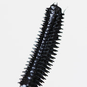 closeup of curved plastic black mascara applicator - totally tubular mascara, the ultimate - half caked makeup