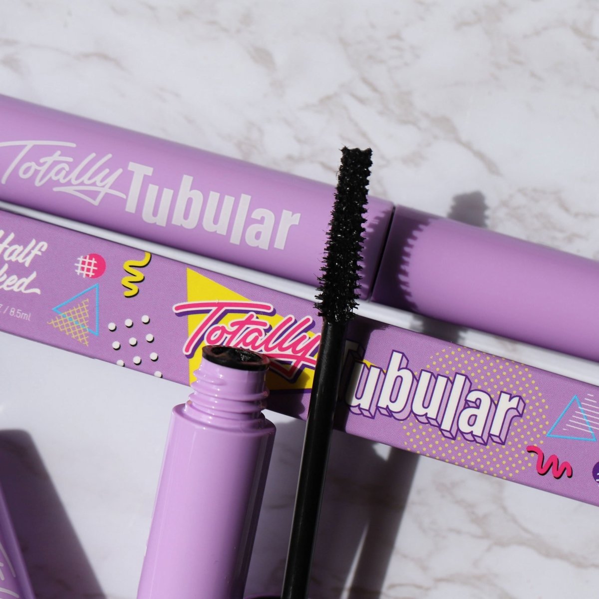 open purple mascara tube with black wire applicator - totally tubular mascara, the dream - half caked makeup